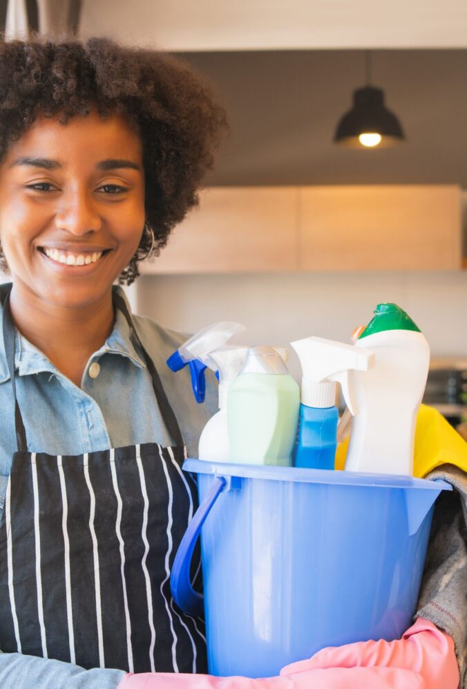 afro-woman-holding-bucket-with-cleaning-items