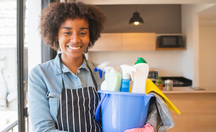 afro-woman-holding-bucket-with-cleaning-items
